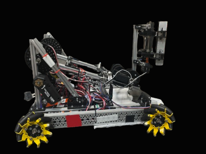 Metal Scraps, the 2023-24 robot, photographed side-on against black, showing its yellow mecanum wheels, aluminium frame and arm